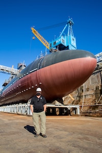 Safety Department (Code 106) Moored Training Ships Project Safety Manager Jon Larrew in front of the USS San Francisco (SSN 711) undergoing Moored Training Ship Conversion at Norfolk Naval Shipyard.