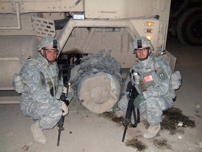 Jon Larrew and Chris Faille pose with the vehicle they rode seven miles in following a damaged tire and rim due to either a gun shot or munition designed to destroy the tire.