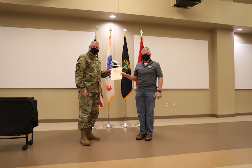 U.S. Army Civil Affairs and Psychological Operations Command (Airborne) Commanding General, Brig. Gen. Jeffrey C. Coggin, presents the Federal Length of Service Award to Billy L. Wells for 10 years of federal service during the Soldier and Department of the Army Civilian recognition award ceremony at USACAPOC(A) Headquarters on Fort Bragg, N.C., Nov. 17, 2020. The recognition award ceremony was held to recognize 12 USACAPOC(A) Soldiers and DA civilians for Federal Length of Service Awards, Honorary Awards, Retirement recognition, and military awards.