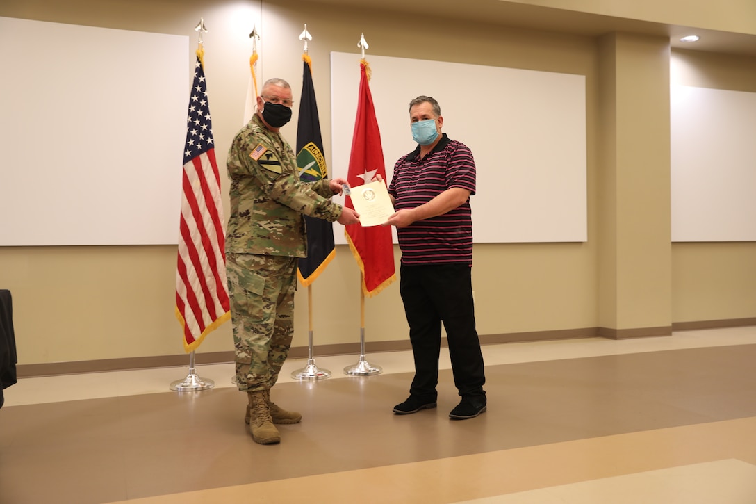U.S. Army Civil Affairs and Psychological Operations Command (Airborne) Commanding General, Brig. Gen. Jeffrey C. Coggin, presents the Federal Length of Service Award to Brian W. Wilhelm for 40 years of federal service during the Soldier and Department of the Army Civilian recognition award ceremony at USACAPOC(A) Headquarters, Fort Bragg, N.C., Nov. 17, 2020. The recognition award ceremony was held to recognize 12 USACAPOC(A) Soldiers and DA civilians for Federal Length of Service Awards, Honorary Awards, Retirement recognition, and military awards.