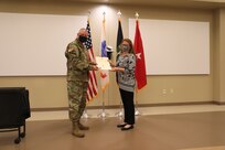 U.S. Army Civil Affairs and Psychological Operations Command (Airborne) Commanding General, Brig. Gen. Jeffrey C. Coggin, presents the Federal Length of Service Award to Elizabeth J. Holman for 40 years of federal service, and recognizes her impending retirement from federal service, presenting a Department of the Army Certificate of Appreciation, during the Soldier and Department of the Army Civilian recognition award ceremony at USACAPOC(A) Headquarters, Fort Bragg, N.C., Nov. 17, 2020. The recognition award ceremony was held to recognize 12 USACAPOC(A) Soldiers and DA civilians for Federal Length of Service Awards, Honorary Awards, Retirement recognition, and military awards.