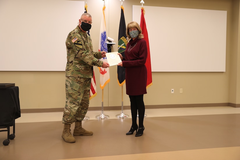 U.S. Army Civil Affairs and Psychological Operations Command (Airborne) Commanding General, Brig. Gen. Jeffrey C. Coggin, presents the Federal Length of Service Award to Kathy L. Futrell for 25 years of federal service during the Soldier and Department of the Army Civilian recognition award ceremony at USACAPOC(A) Headquarters, Fort Bragg, N.C., Nov. 17, 2020. The recognition award ceremony was held to recognize 12 USACAPOC(A) Soldiers and DA civilians for Federal Length of Service Awards, Honorary Awards, Retirement recognition, and military awards.