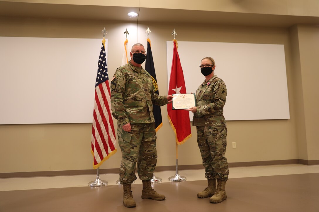 U.S. Army Civil Affairs and Psychological Operations Command (Airborne) Commanding General, Brig. Gen. Jeffrey C. Coggin, presents the Meritorious Service Medal to Lt. Col. Kristy M. Wolter during the Soldier and Department of the Army Civilian recognition award ceremony at USACAPOC(A) Headquarters, Fort Bragg, N.C., Nov. 17, 2020 for exceptionally meritorious service as the USACAPOC(A) Deputy G-3/5/7. The recognition award ceremony was held to recognize 12 USACAPOC(A) Soldiers and DA civilians for Federal Length of Service Awards, Honorary Awards, Retirement recognition, and military awards.