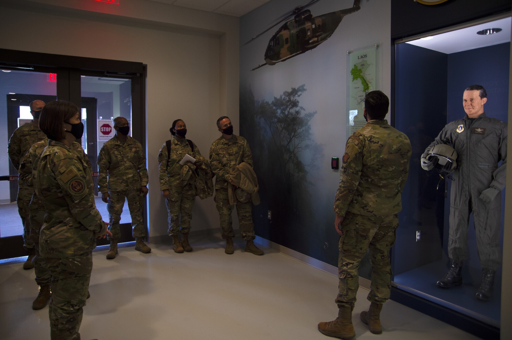 Senior Airman Kyle Ray, 1st Helicopter Squadron aviation resource management, briefs Chief Master Sgt. of the Air Force JoAnne Bass and her team on the namesake history of the 1st Helicopter Squadron at Joint Base Andrews, Md., Nov. 23, 2020. The 1st HS was first activated in February 1944. (U.S. Air Force Photo by Senior Airman Kaylea Berry)
