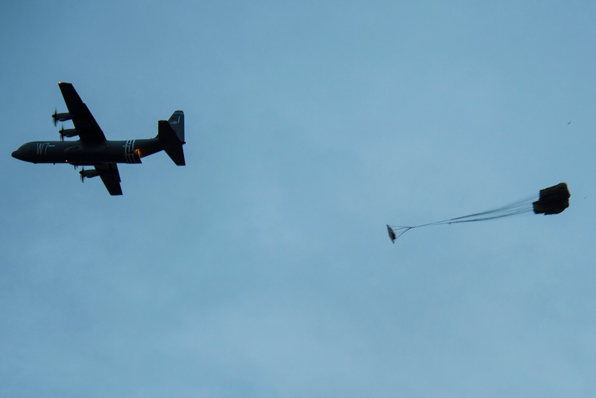 A U.S. Air Force C-130J Super Hercules aircraft drops heavy cargo over a dropzone during exercise Agile Wolf 21-01.