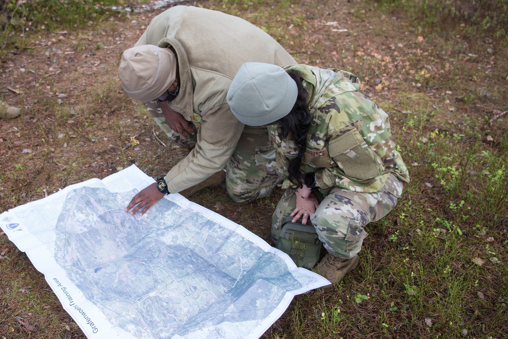 U.S. Airmen assigned to the 435th Contingency Response Group read a map while participating in a Survival, Evasion, Resistance and Escape navigation course during exercise Agile Wolf 21-01.