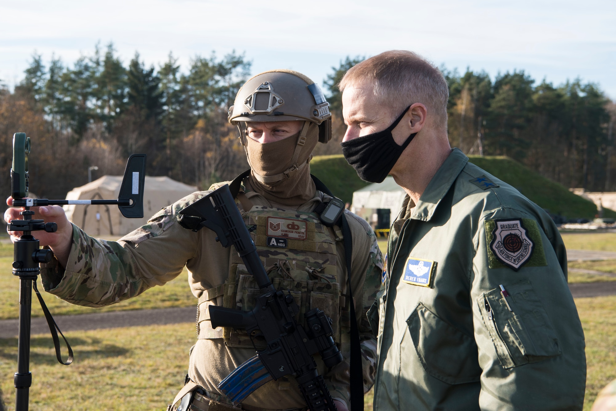 U.S. Air Force Tech. Sgt. Cameron Piontek, 435th Contingency Response Squadron contingency air traffic controller, left, shows Maj. Gen. Derek France, Headquarters U.S. Air Forces in Europe-Air Forces Africa strategic deterrence and nuclear integration operations director, a joint-terminal attack controller wind meter during exercise Agile Wolf 21-01.