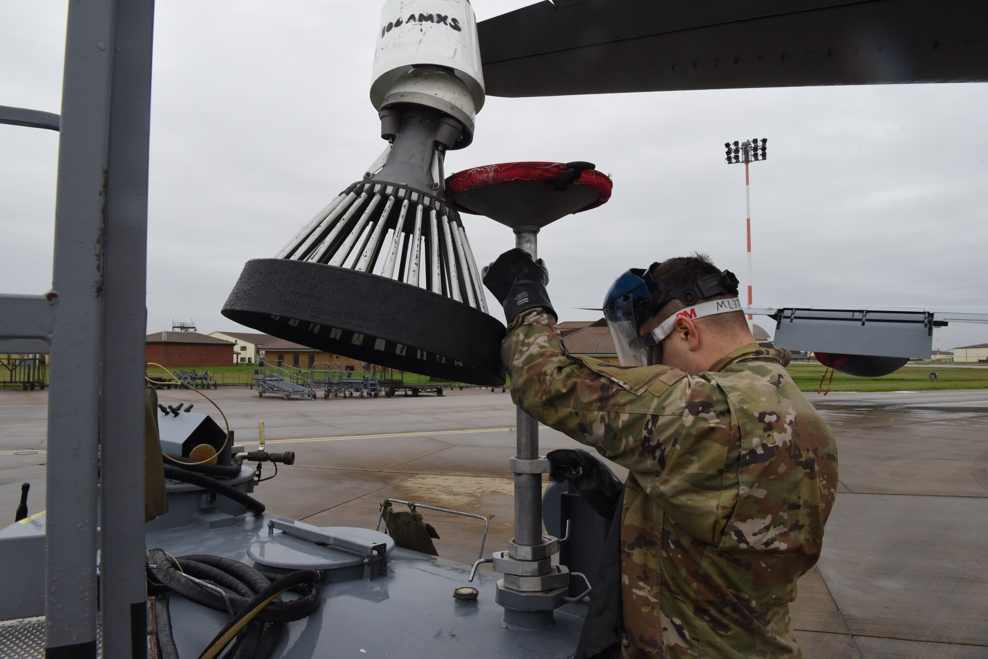 U.S. Air Force Airman 1st Class Julian Nailing, 100th Aircraft Maintenance Squadron crew chief, prepares to detach the drogue from a KC-135 Stratotanker aircraft at Royal Air Force Mildenhall, England, Oct. 29, 2020. Prior to detaching the drogue, crew chiefs must drain the drogue of any residual fuel. (U.S. Air Force photo by Airman 1st Class David Busby)