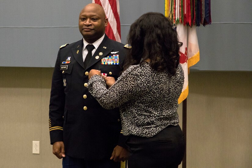 Maj. Paul Sheppard’s wife pins the Meritorious Service Medal on her husband during his retirement ceremony at U.S. Army Central headquarters on Shaw Air Force Base, S.C., Nov. 12, 2020. Sheppard, a native of Newberry, South Carolina, retired from the military after serving 39 years. (U.S. Army photo by Pfc. Keon Horton)