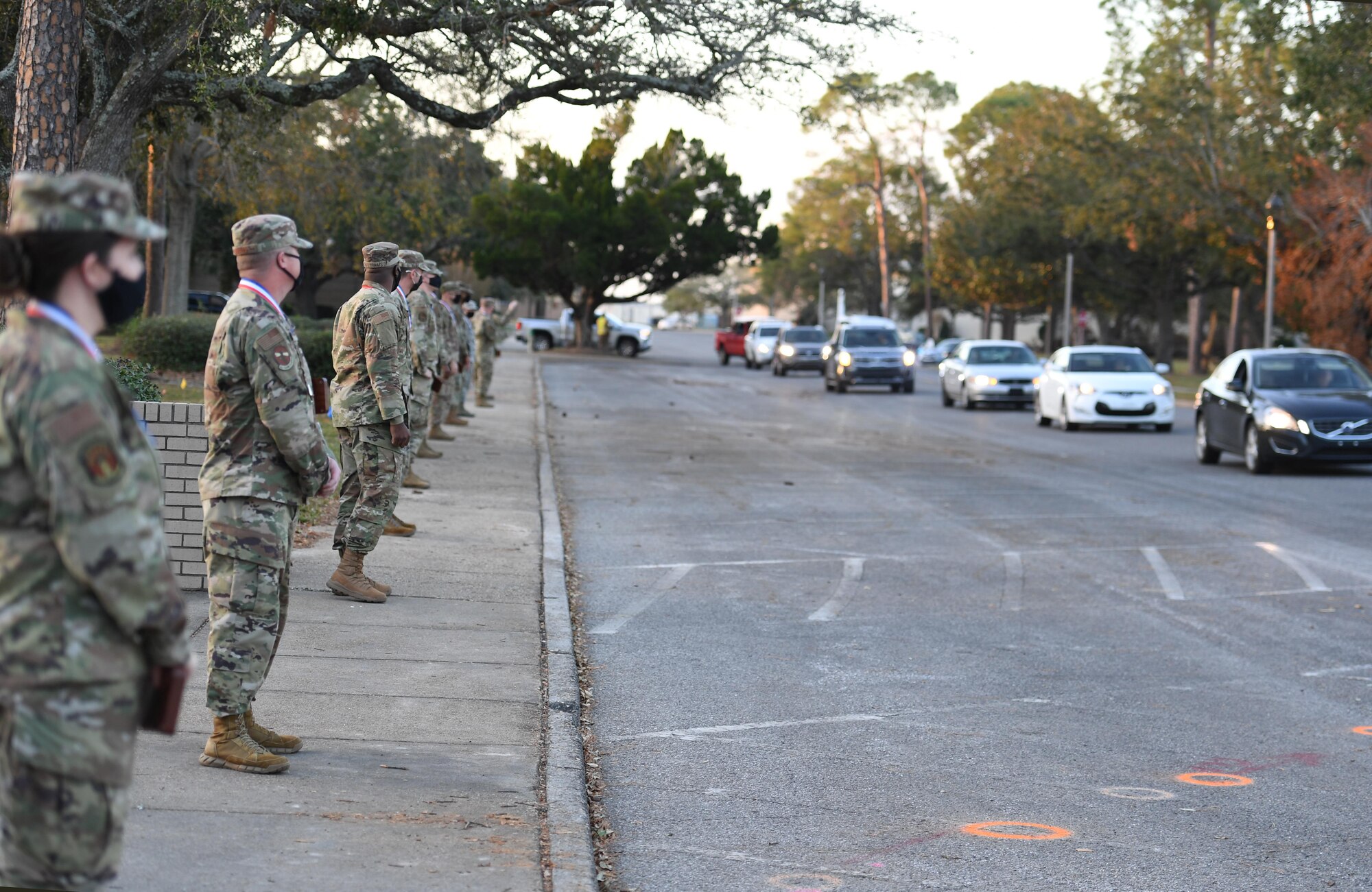 Keesler Senior Noncommissioned Officer inductees watch Keesler personnel participate in a drive-thru congratulatory parade during the Keesler Senior NCO Induction Ceremony outside Mathies Hall at Keesler Air Force Base, Mississippi, Nov. 19, 2020. Over 20 Airmen were recognized during the ceremony. (U.S. Air Force photo by Kemberly Groue)