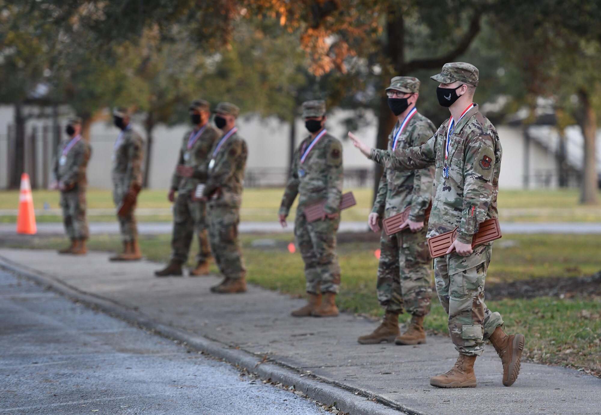 Keesler Senior Noncommissioned Officer inductees wave to passer-byes during the Keesler Senior NCO Induction Ceremony outside Mathies Hall at Keesler Air Force Base, Mississippi, Nov. 19, 2020. Over 20 Airmen were recognized during the ceremony, which also included a drive-thru congratulatory parade by Keesler personnel. (U.S. Air Force photo by Kemberly Groue)