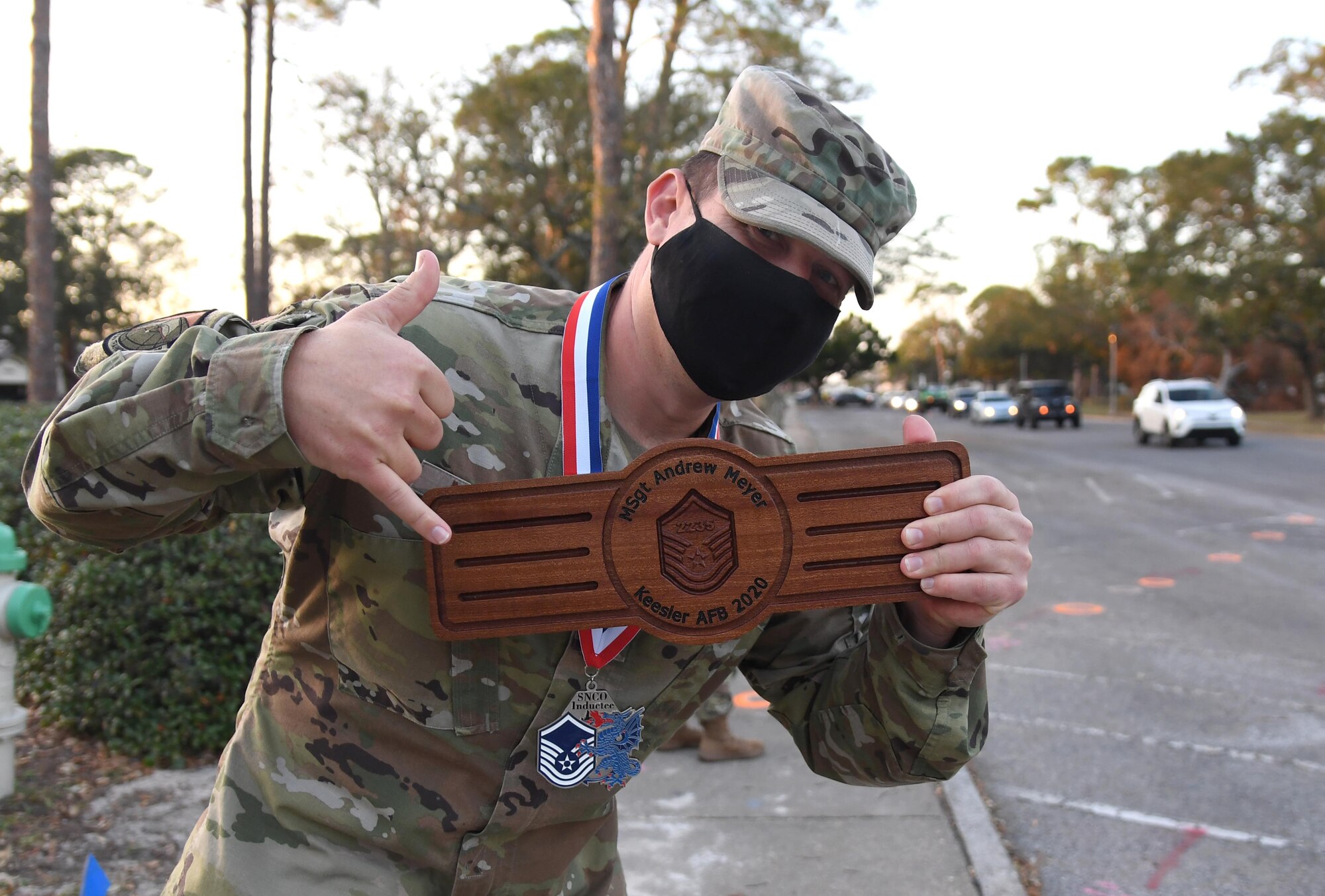 U.S. Air Force Tech. Sgt. Andrew Meyer, 334th Training Squadron instructor, holds a plaque during the Keesler Senior Noncommissioned Officer Induction Ceremony outside Mathies Hall at Keesler Air Force Base, Mississippi, Nov. 19, 2020. Over 20 Airmen were recognized during the ceremony, which also included a drive-thru congratulatory parade by Keesler personnel. (U.S. Air Force photo by Kemberly Groue)