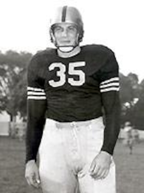 A man in a football uniform and helmet poses for a photo.