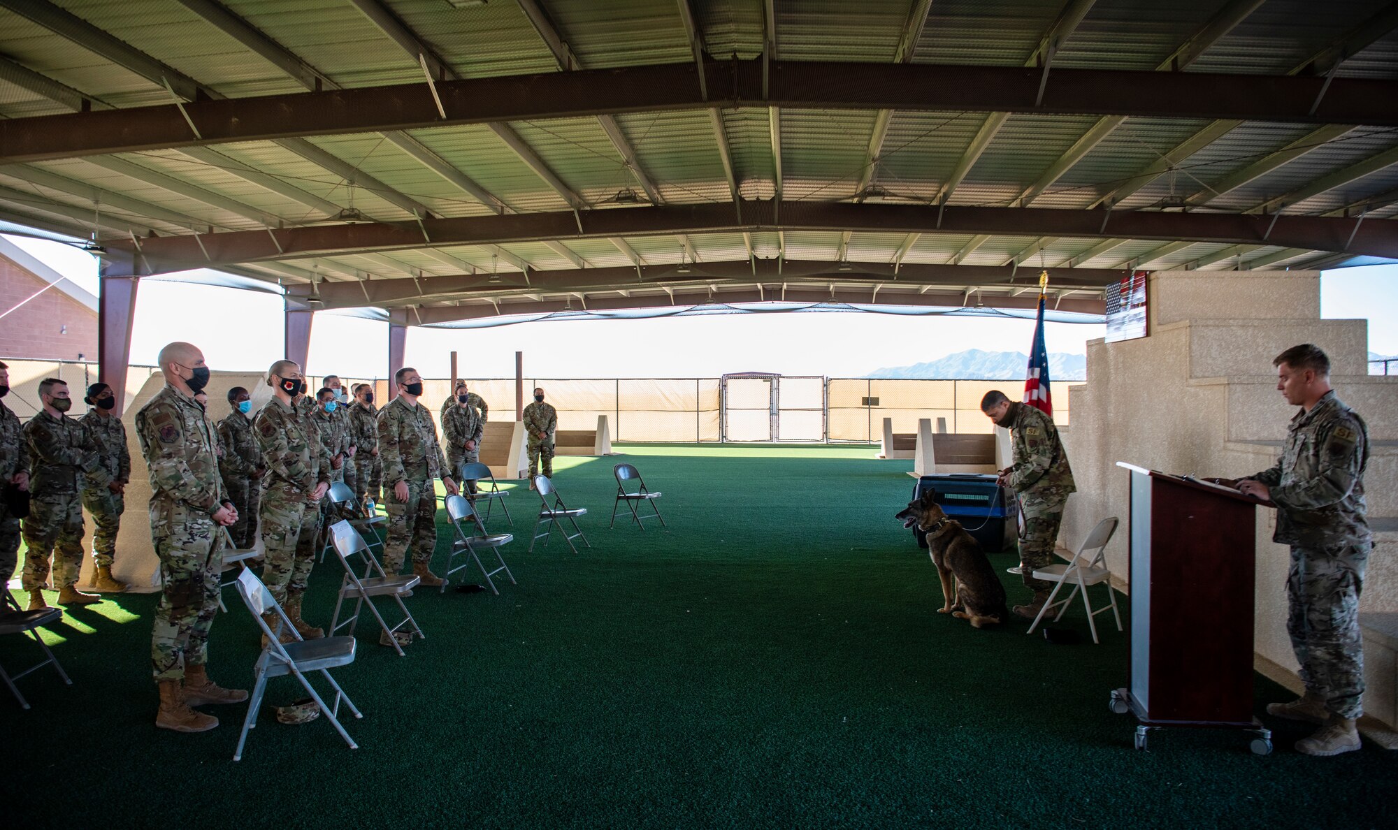 An audience stands as the military working dog is retired.