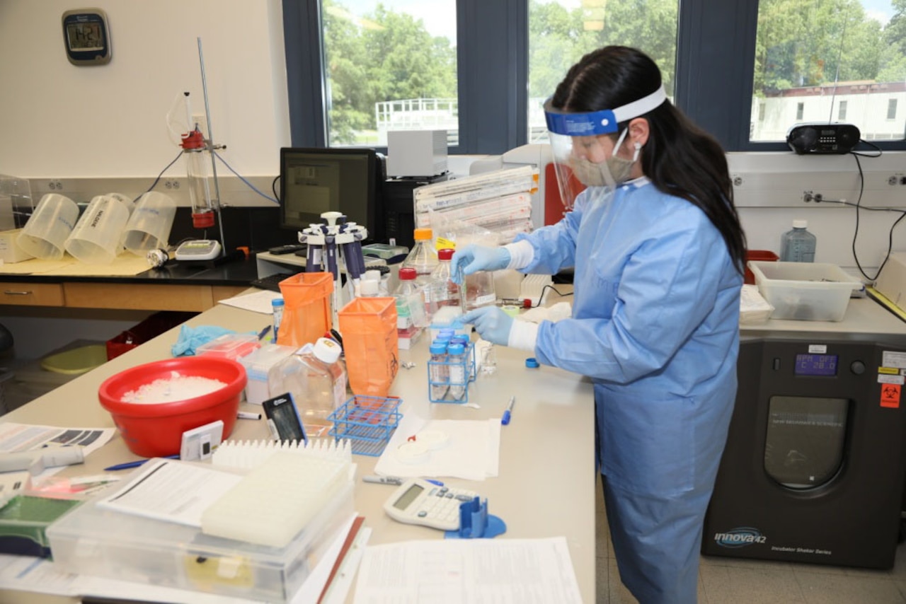 A lab manager in full PPE works in a coronavirus lab.