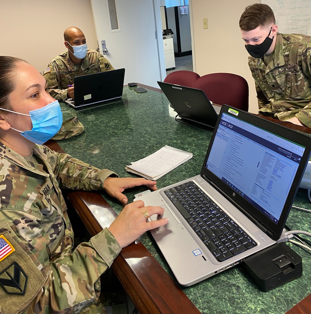 (From left) Sgt. 1st Class Mayda Rivera-Pena, Sgt. Tito Sanchez and Spec. Dylan Livingston review use of the Virtual Contracting Enterprise-Paperless Contract Files acquisition management system Nov. 9 at Fort Stewart, Georgia, as part of a rotation for developmental training.
