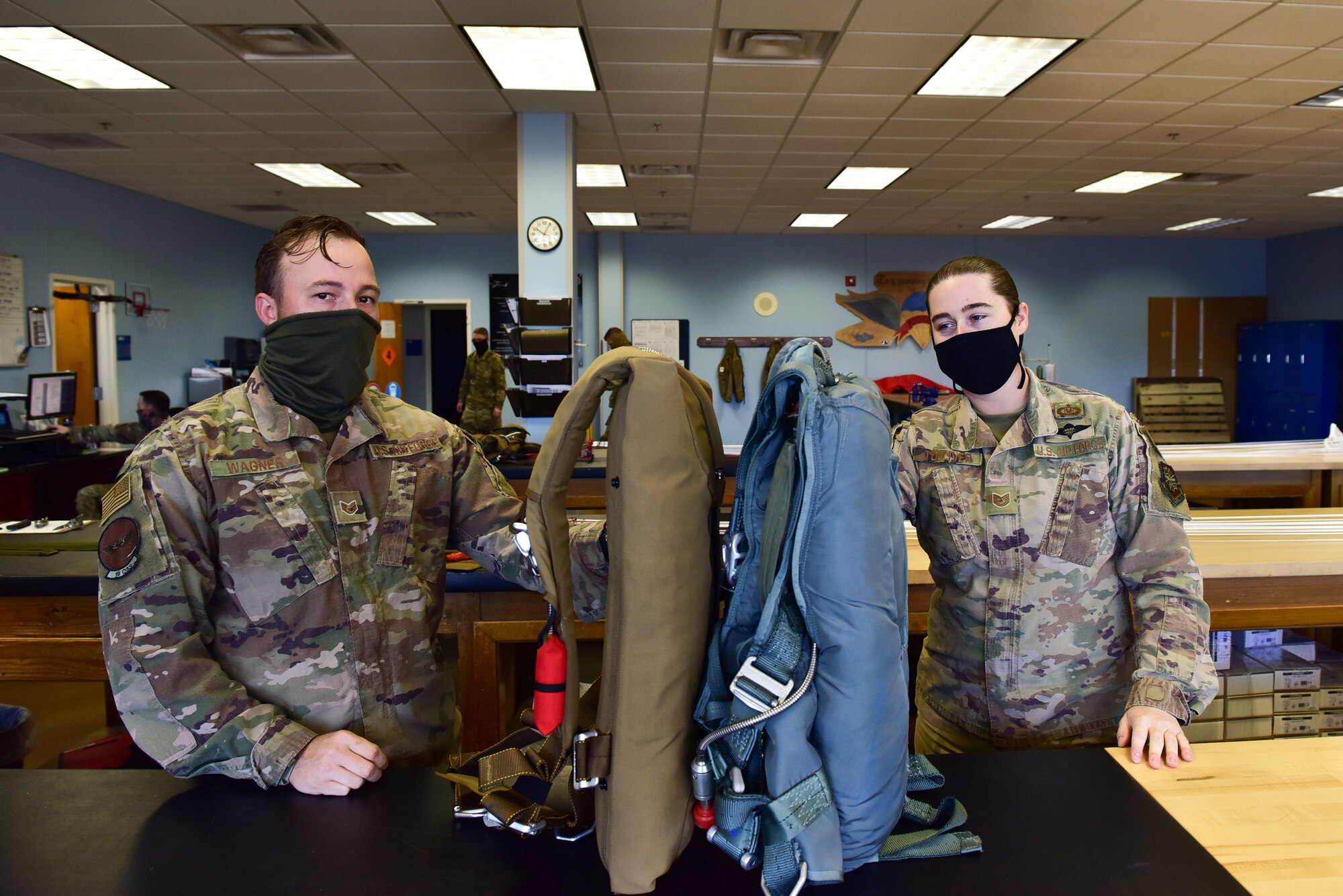 two men hold parachutes