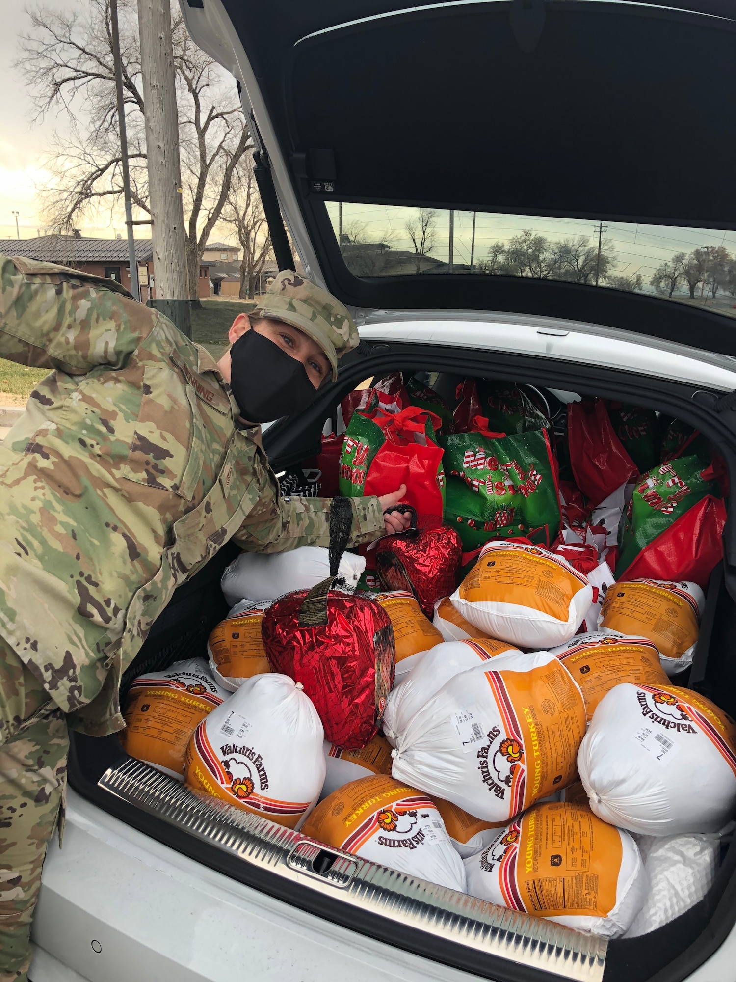 Master Sgt. Erin Henning, 388th Maintenance Group first sergeant, poses next to a trunk full of Thanksgiving food items Nov. 20, 2020, at Hill Air Force Base, Utah. Operation Warm Heart, a first sergeant’s program, teamed with the commissary to deliver bags filled with turkeys, hams and other goods items to assist Airmen and their families with the upcoming holiday. (Courtesy photo)