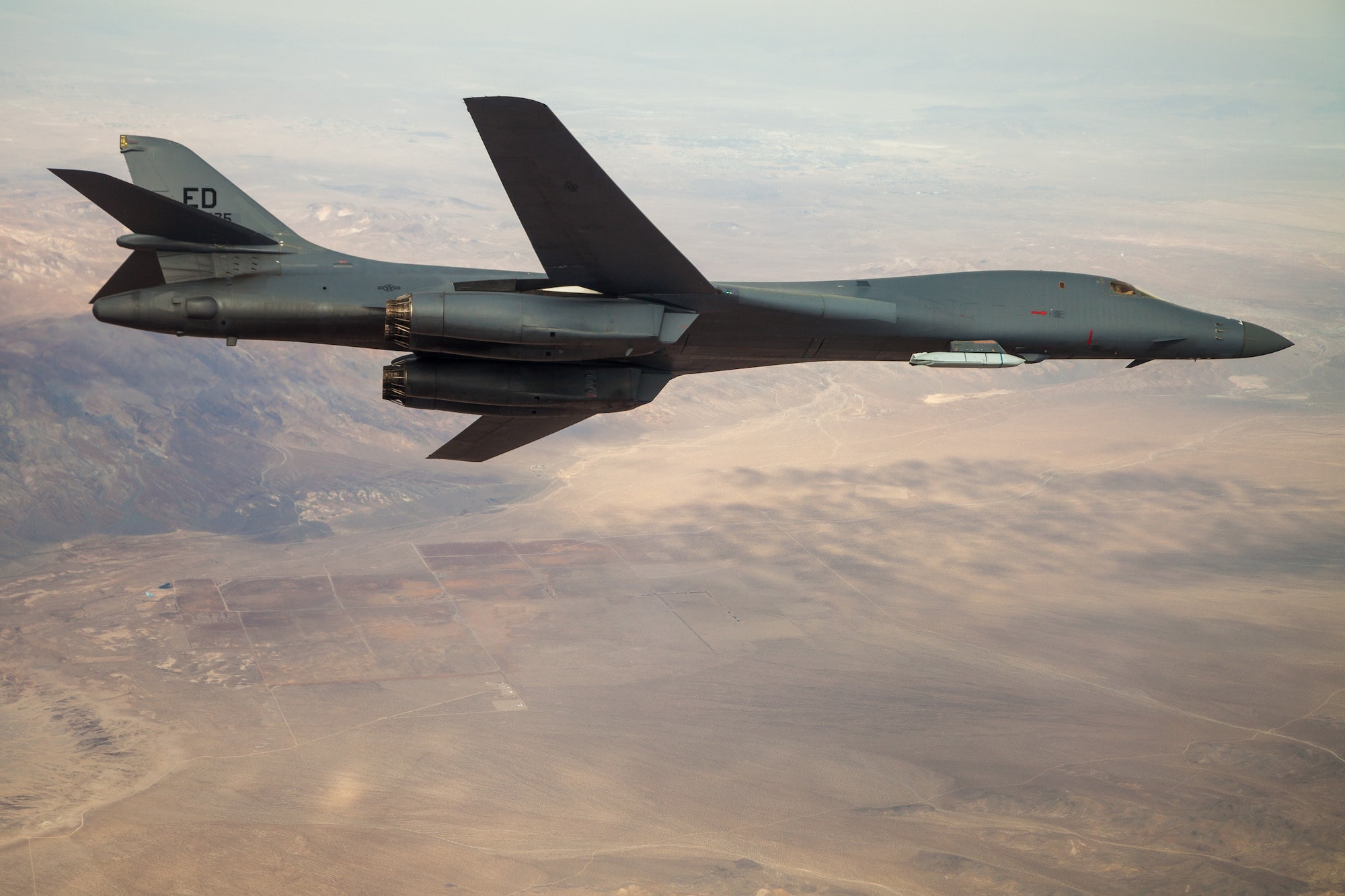 A B-1B Lancer with a Joint Air-to-Surface Standoff Missile (JASSM) flies in the skies above Edwards Air Force Base, California, Nov. 20. The flight was a demonstration of the B-1B’s external weapons carriage capabilities. (Air Force photo by Ethan Wagner)