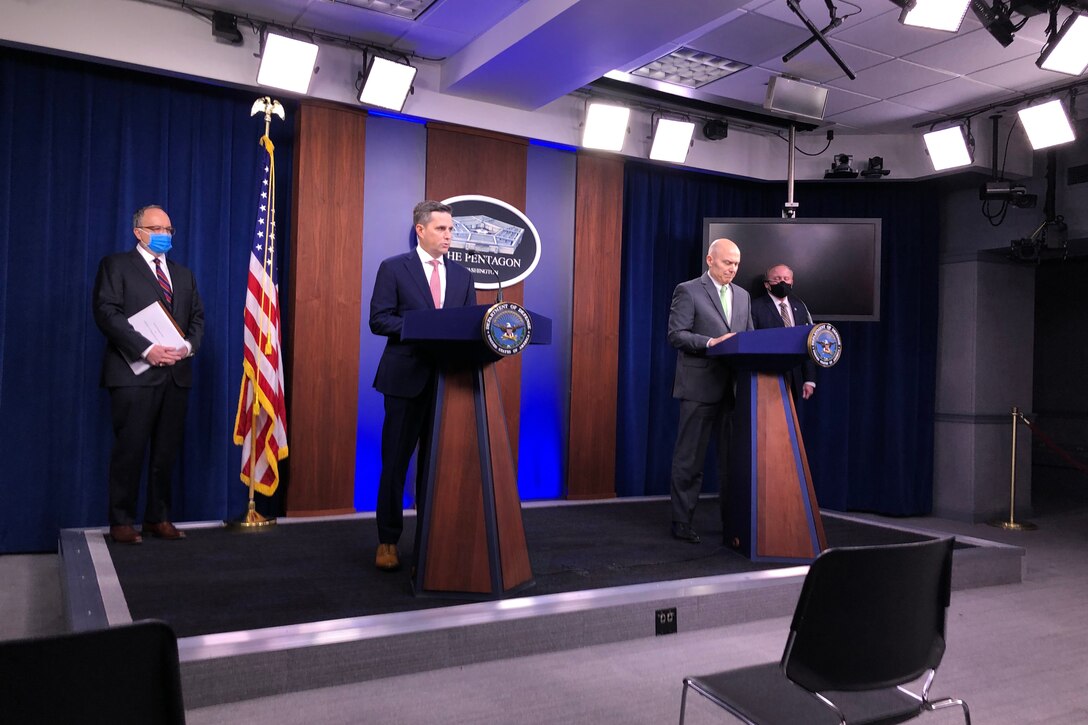 Men stand at lecterns in the Pentagon briefing room.