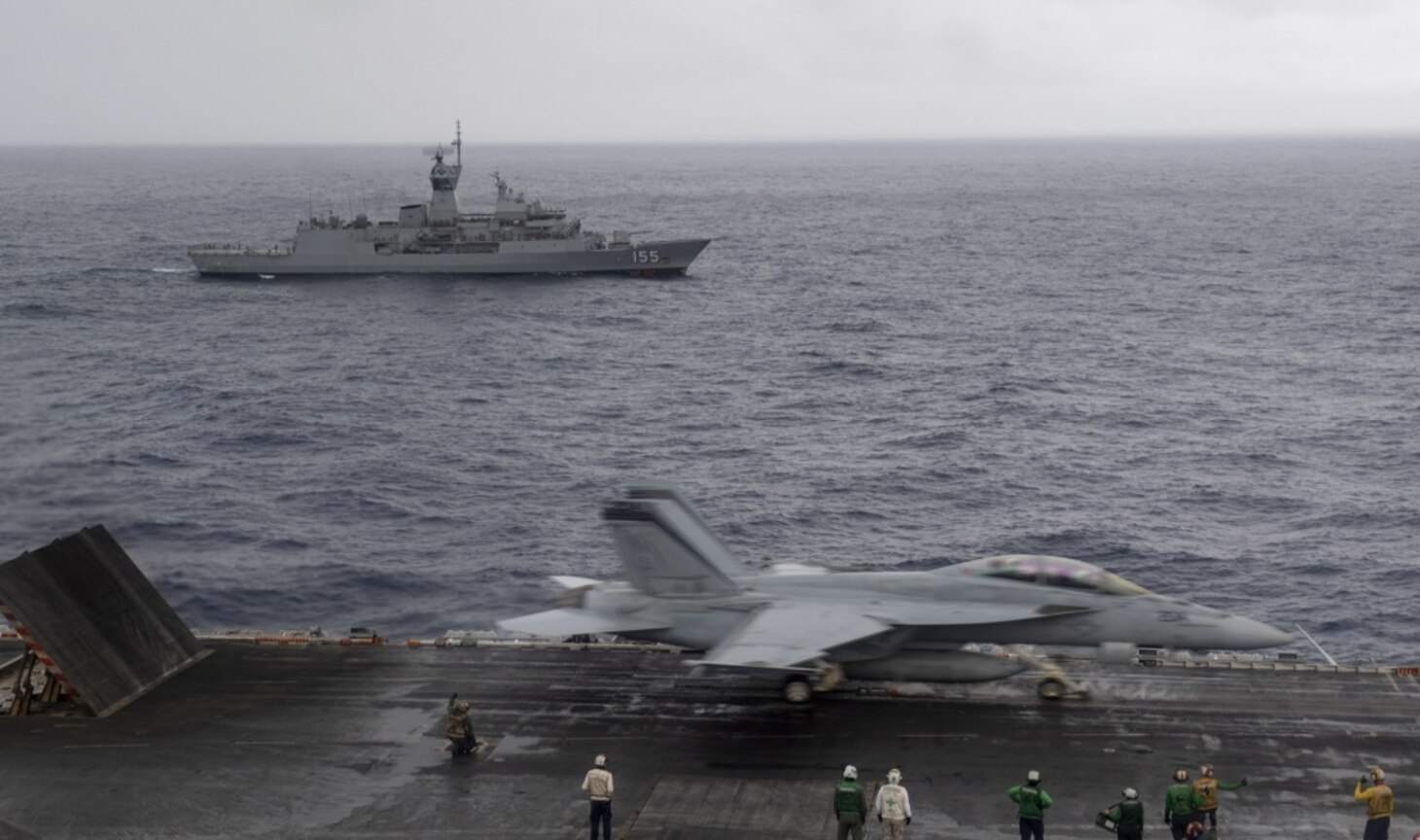 INDIAN OCEAN (Nov. 23, 2020) The Royal Australian Navy Anzac-class frigate HMAS Ballarat (FFH 155) steams alongside the aircraft carrier USS Nimitz (CVN 68) as an F/A-18F Super Hornet, assigned to the "Mighty Shrikes" of Strike Fighter Squadron (VFA) 94, launches off the flight deck of the Nimitz. Nimitz, the flagship of Carrier Strike Group 11, is deployed conducting maritime security operations and theater security cooperation efforts.
