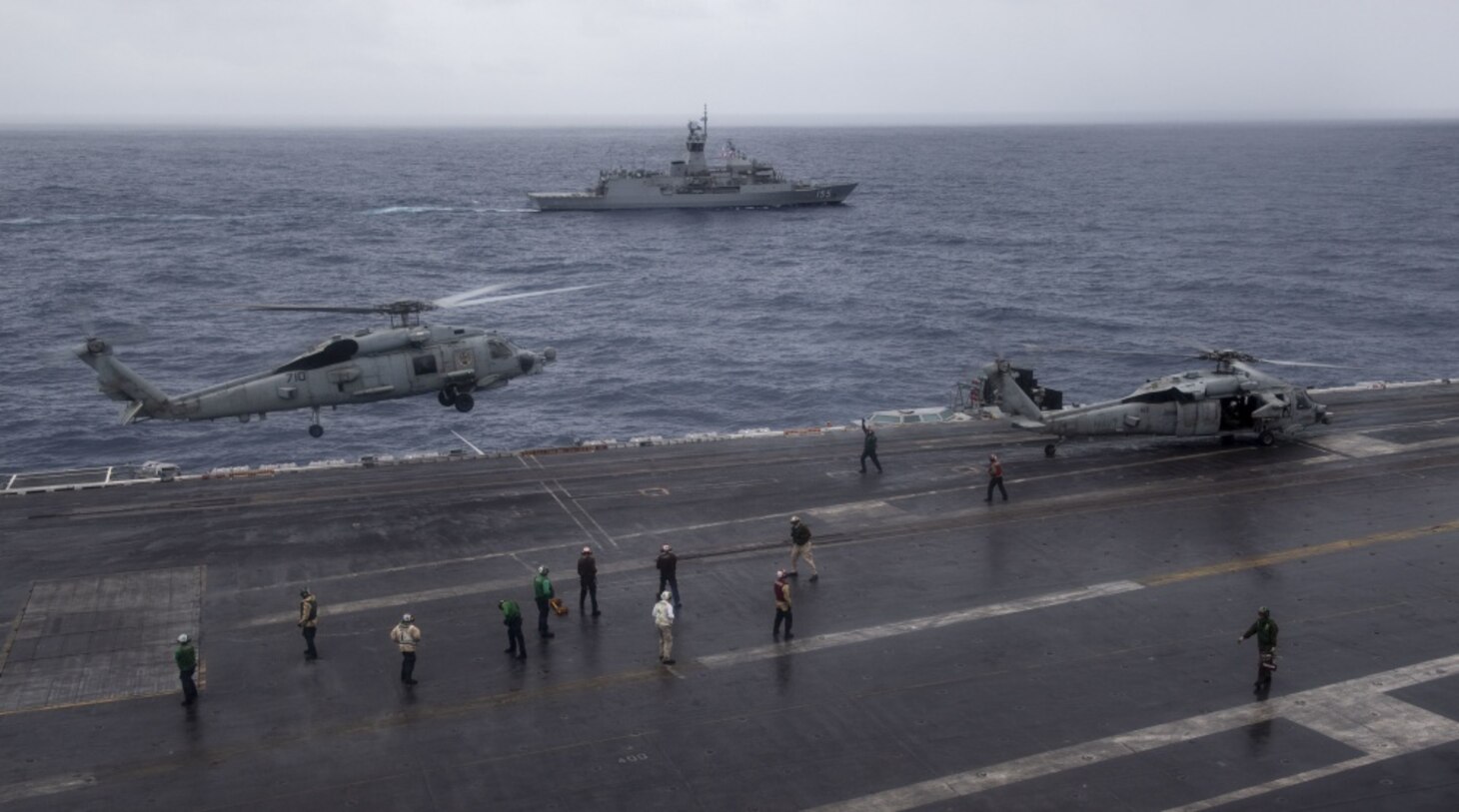INDIAN OCEAN (Nov. 23, 2020) The Royal Australian Navy Anzac-class frigate HMAS Ballarat (FFH 155) steams alongside the aircraft carrier USS Nimitz (CVN 68) as an MH-60R Sea Hawk helicopter, from the “Battlecats” of Helicopter Maritime Strike Squadron (HSM) 73, descends on the flight deck of the Nimitz. Nimitz, the flagship of Carrier Strike Group 11, is deployed conducting maritime security operations and theater security cooperation efforts.