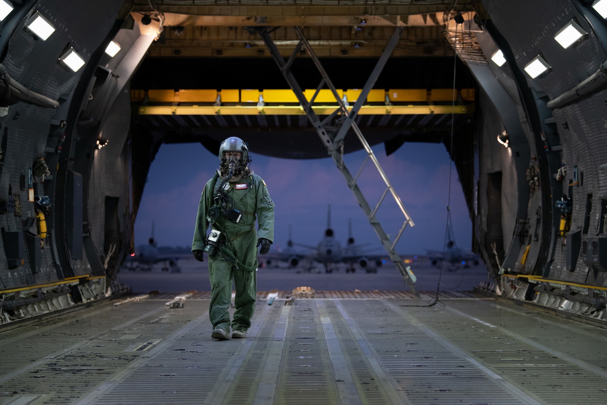 U.S. Air Force Staff Sgt. Cameron DiMatteo, 22nd Airlift Squadron loadmaster, walks inside a C-5M Super Galaxy during a base exercise Nov. 18, 2020, at Travis Air Force Base, California. Airmen at Travis AFB participate in readiness exercises to ensure they can operate in contested environments. (U.S. Air Force photo by Chustine Minoda)