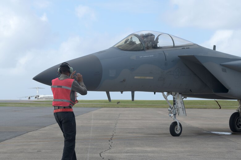 An F-15C Eagle crew chief leads an F-15C Eagle into a parking space to be refueled by the 18th Logistics Readiness Squadron, during a “Super Surge,” Nov. 18, 2020, at Kadena Air Base, Japan. The 44th and 67th Fighter Squadrons set a new record for the most F-15C Eagles flown in a week at 437 sorties; the previous record was 245 sorties. (U.S. Air Force photo by Airman 1st Class Rebeckah Medeiros)