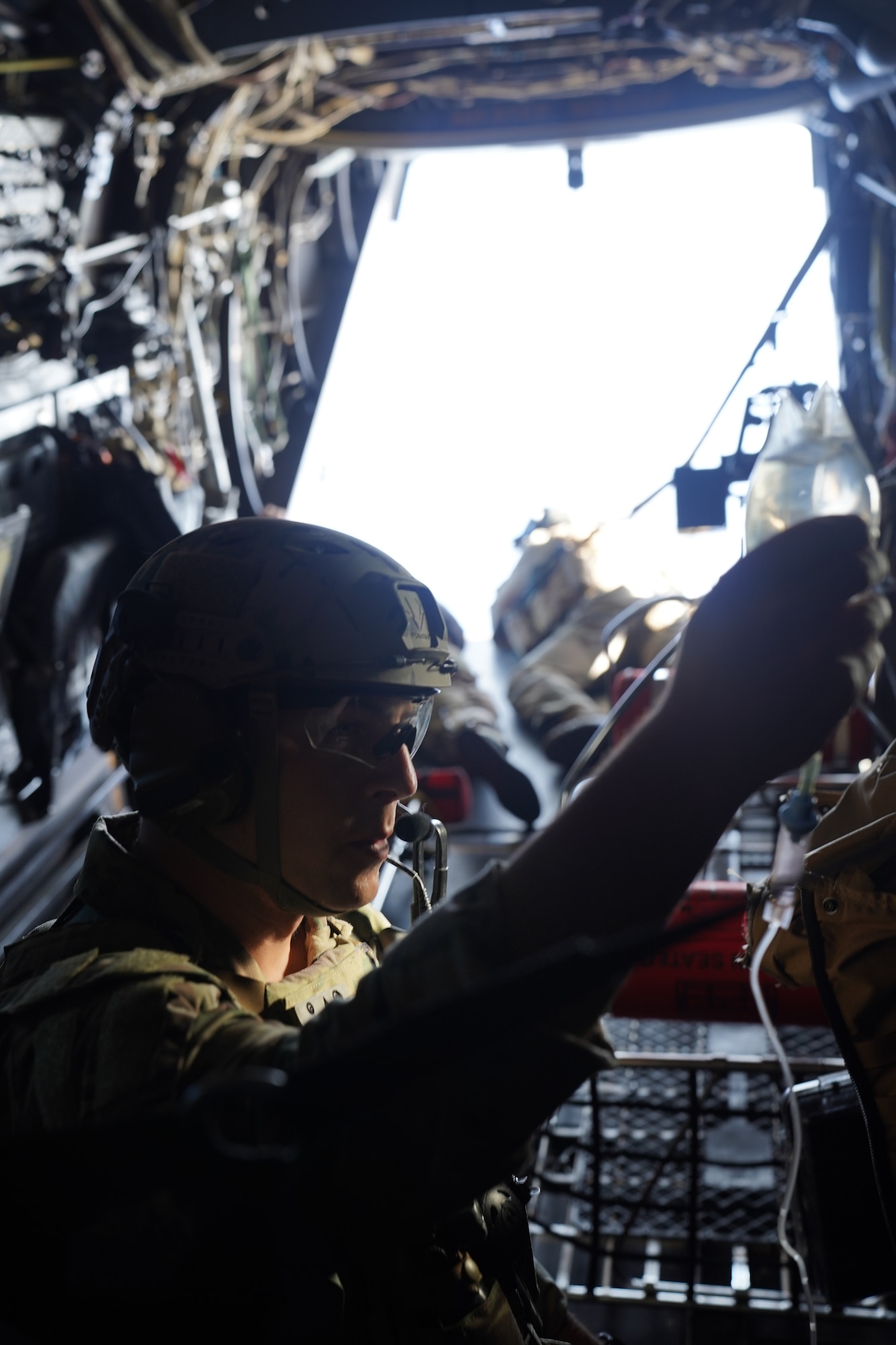 Staff Sgt. Codie White, 353rd Special Operations Support Squadron special operations independent duty medic, prepares a bag of saline fluids in flight ahead of an open water personnel recovery training scenario off the coast of Okinawa, Japan, Nov. 19, 2020.