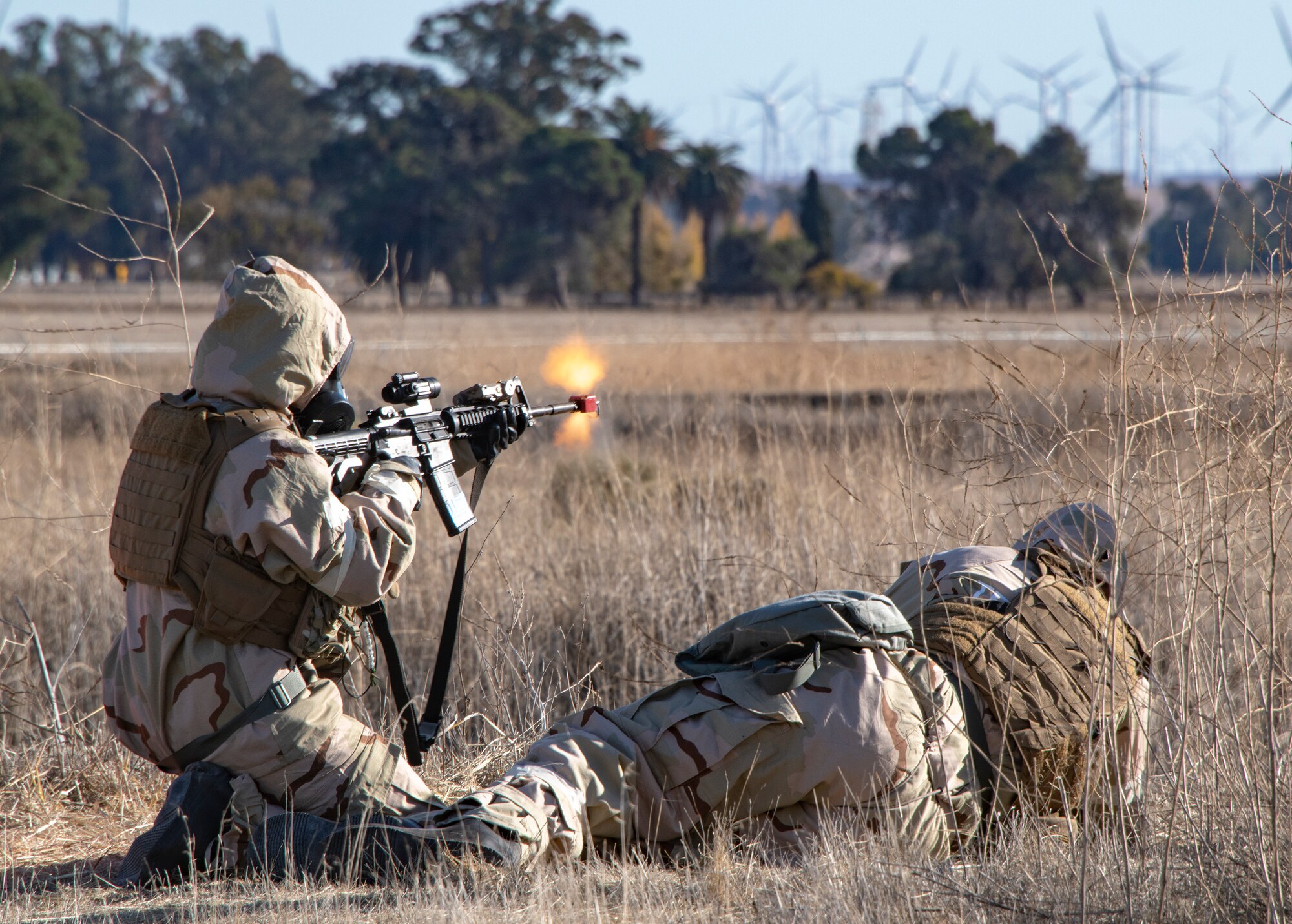 U. S. Air Force Airman 1st Class Emily Hardbarger, 60th Security Forces Squadron patrolman, protects a fallen comrade played by Senior Airman Vincent Mwita, 60th SFS patrolman, during an exercise Nov. 19, 2020, at Travis Air Force Base, California. Airmen at Travis AFB participate in readiness exercises to ensure they can operate in contested environments. (U.S. Air Force photo by Heide Couch)