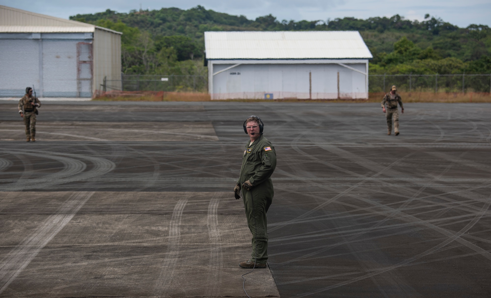 U.S. Chief Master Sgt. Lester Farley, a loadmaster assigned to the 36th Airlift Squadron, Yokota Air Base, Japan, calls in two 736th Security Forces Airmen from a security perimeter before takeoff at Palau International Airport, Palau, during a Dynamic Force Employment, Nov. 23, 2020. DFE is an operational platform that allows our forces to be strategically predictable and operationally unpredictable. The U.S. Air Force is postured and ready to respond to crises and contingencies throughout the U.S. Indo-Pacific Command, contributing to regional stability and a free and open Indo-Pacific. (U.S. Air Force photo by Senior Airman Michael S. Murphy)
