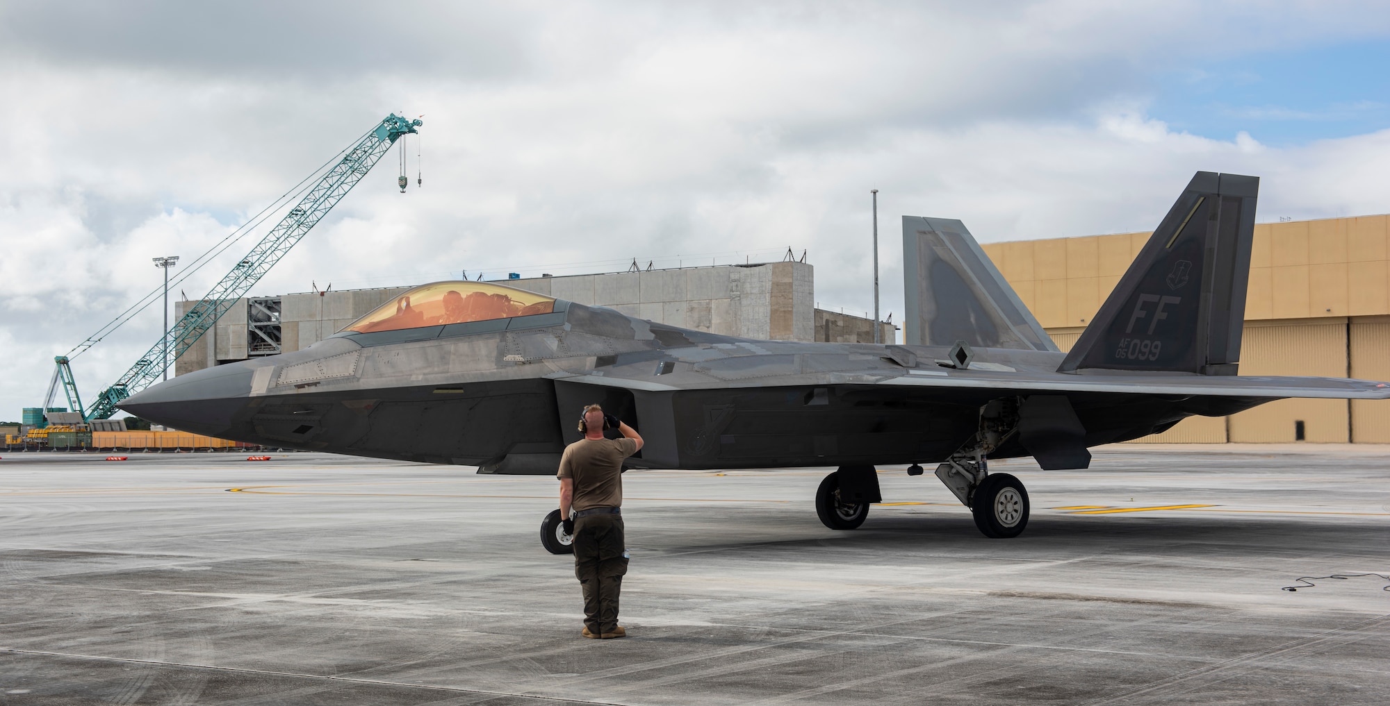 U.S. Air Force Staff Sgt. Jacob Bonter, a dedicated crew chief assigned to the 94th Fighter Squadron, salutes to an F-22 assigned to the 94th FS as it taxies off after completing a hot refuel during a Dynamic Force Employment at Andersen Air Force Base, Guam, Nov. 22, 2020. DFE is an operational platform that allows our forces to be strategically predictable and operationally unpredictable. The United States security presence, along with our allies and partners, underpins the peace and stability that has enabled the Indo-Pacific region to develop and prosper for more than seven decades. (U.S. Air Force photo by Senior Airman Michael S. Murphy)