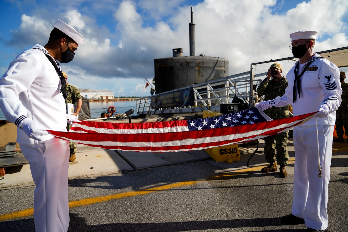 Sailors assigned to USS Oklahoma City (SSN 723) fold the national ensign during a retirement ceremony for Machinist�s Mate (Nuclear) 1st Class Nicholas Miller on the pier onboard Naval Base Guam.