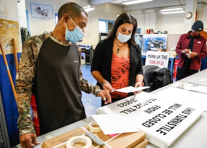 Tanya Sparrow and Torrence Rabb perform a quality control check on a sign product.