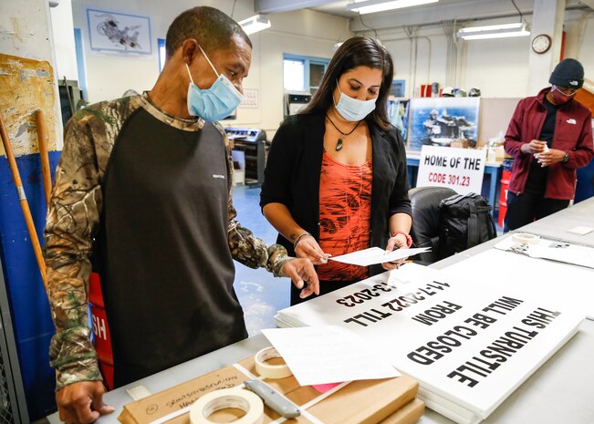 Tanya Sparrow and Torrence Rabb perform a quality control check on a sign product.