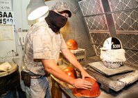 Paul Darden sands a hardhat to prepare it for a new coat of paint.