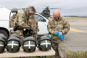 U.S. Army Gen. Christopher Cavoli, right, U.S. Army Europe and Africa Commanding General, puts on gloves before putting on a passenger helmet to board the Royal Air Force CH-47 Chinook helicopter for a flight to South Cerney, England, at Royal Air Force Fairford, England, Nov. 17, 2020, in support of NATO Exercise Loyal Leda 2020 (LOLE20). Allied Land Command (LANDCOM) conducted a combat readiness evaluation on the NATO Headquarters Allied Rapid Reaction Corp (ARRC) during LOLE20, which took place at RAF Fairford and South Cerney, England, Nov. 9-19, 2020. This was a complex multi-domain exercise designed to test the war-fighting capabilities of the ARRC in a COVID-19 environment including combat operations. LOLE20 was a key NATO exercise to validate and certify the Gloucester-based ARRC as a NATO war-fighting corps at full operational readiness, capable of commanding up to 120,000 multinational troops across a full spectrum of military operations. (U.S. Air Force photo by Senior Airman Jennifer Zima)