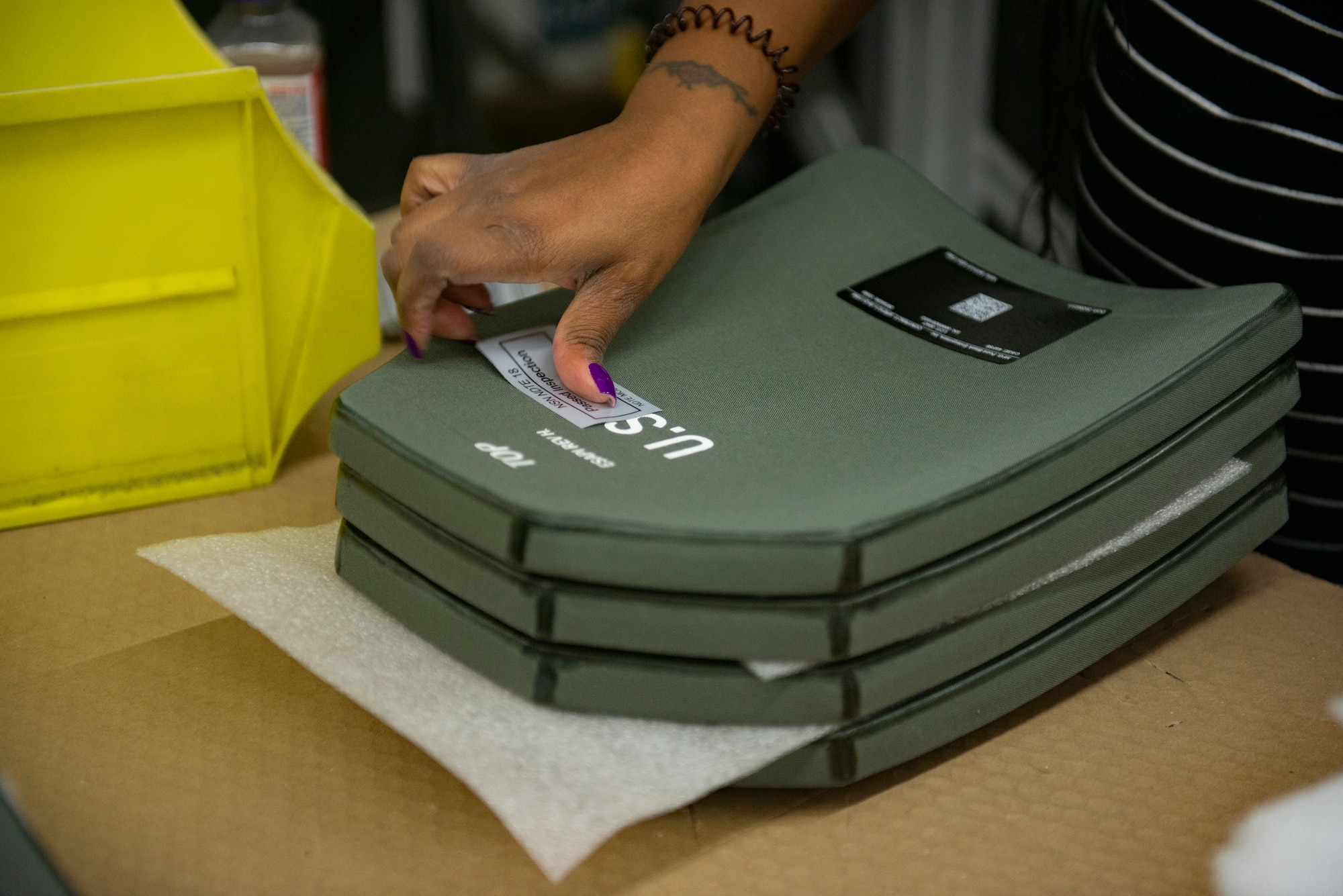 Jazman Brooke, Department of Defense contractor, marks a ballistic vest plate that has passed inspection at Ramstein Air Base, Germany, Oct. 29, 2020.