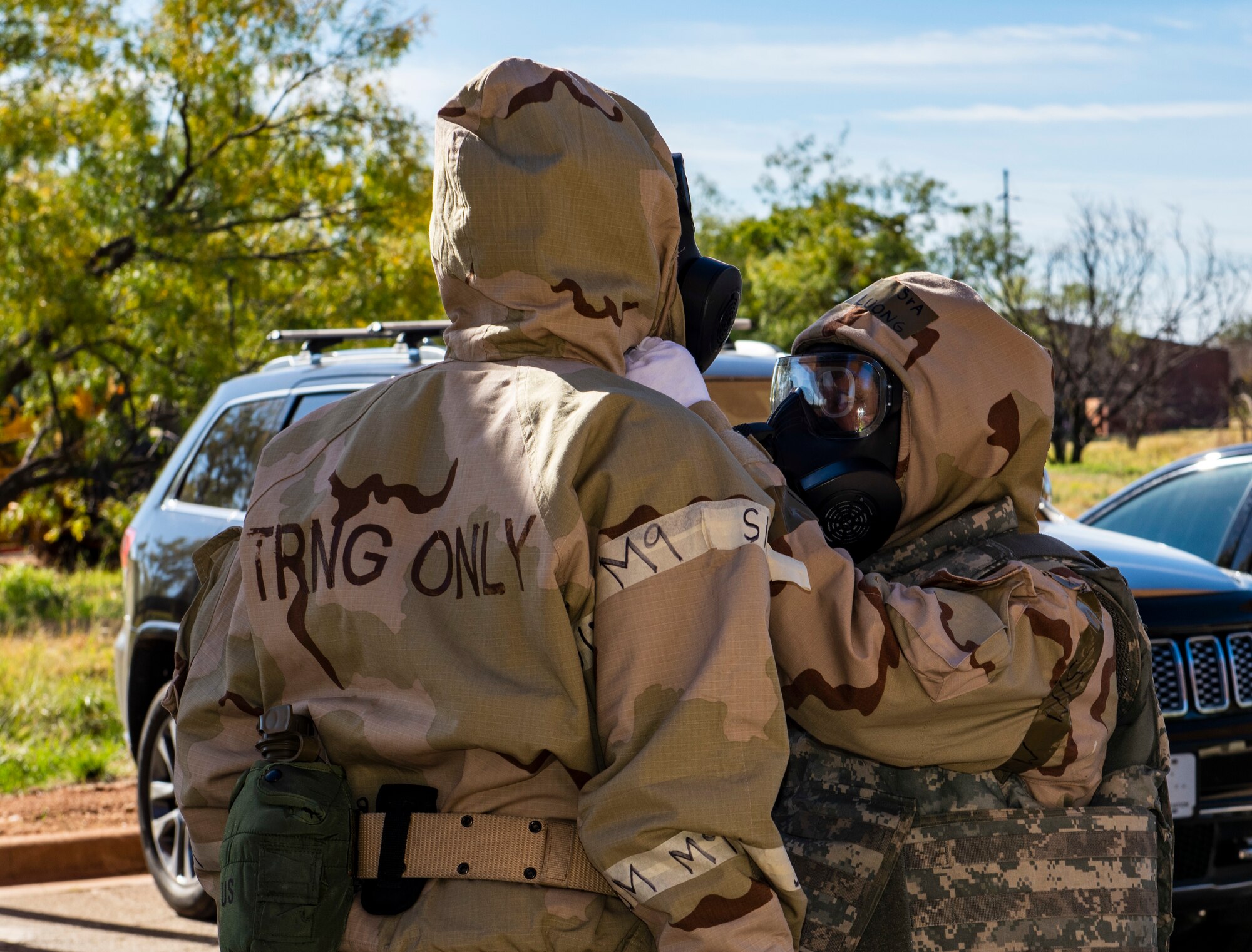 Senior Airman Dieu Luong, 317th Operations Support Squadron aircrew flight equipment technician, right, helps secure the gas mask of Airman 1st Class Tristan Roe, 317th OSS aircrew flight equipment technician, during Exercise Chemical Fury at Dyess Air Force Base, Texas, Nov. 17, 2020.