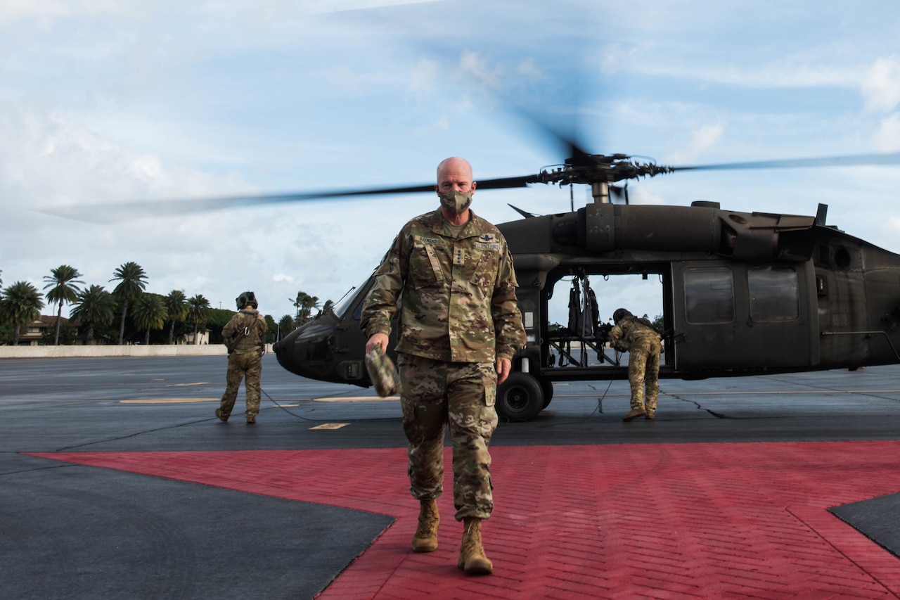 A man walks away from a helicopter.