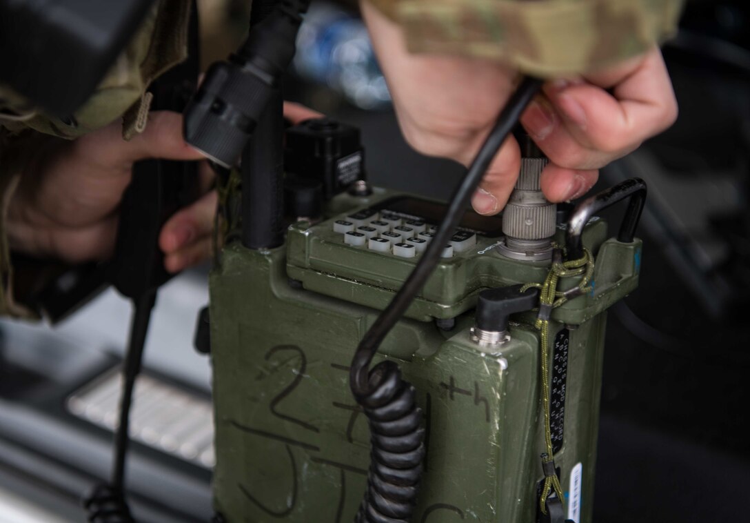 Close up of hand putting plug into radio.