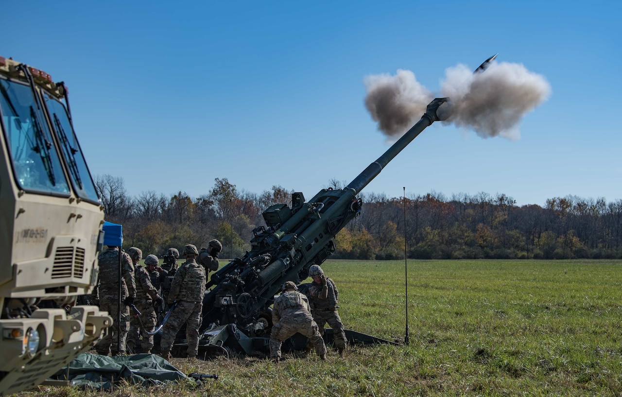 A piece of artillery fires in a field.
