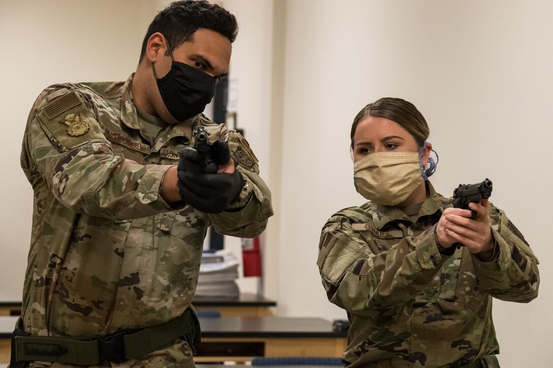 An airman gives weapons instructions to a student.