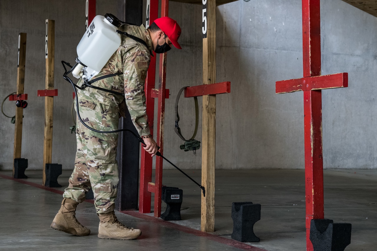 An airman sanitizes indoor shooting stations.