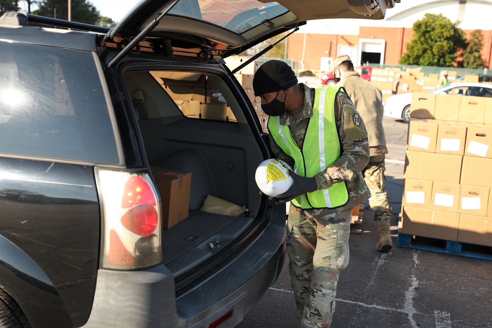 Sgt. Shaquille Ralls, assigned to the North Carolina Army National Guard’s G Company, 230th Brigade Support Battalion, places a frozen hen into a car during a mass food distribution sponsored by the Second Harvest Food Bank of Southeastern North Carolina at the Crown Coliseum in Fayetteville Nov. 24, 2020. A team of 27 Soldiers and Airmen supported the event.