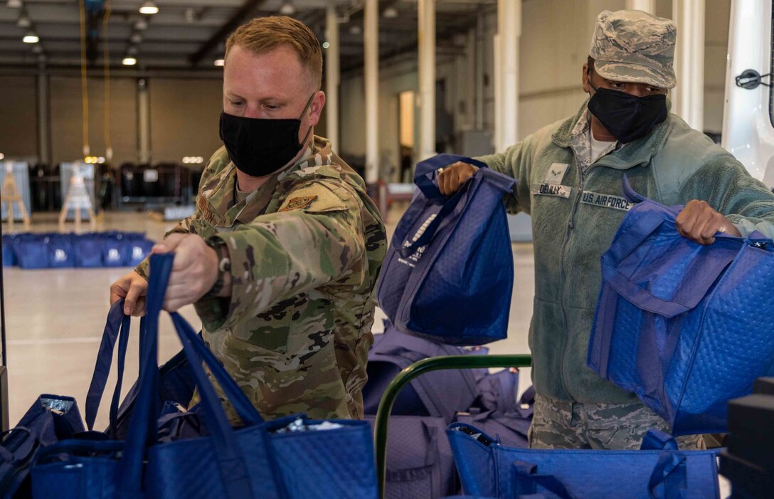 Master Sgt. Christopher Anderson, 436th Communication Squadron first sergeant and Airman 1st Class Zion DeLilly, 436th Communication Squadron radio frequency technician, load a van with Thanksgiving holiday food bags for Team Dover Nov. 23, 2020, at Dover Air Force Base, Delaware. Dover first sergeants, Key Spouses, Dover Spouses Group and other volunteers helped deliver 260 bags of Thanksgiving dinner kits for Airmen including two whole chickens, canned vegetables and pie ingredients. (U.S. Air Force photo by Airman 1st Class Faith Schaefer)