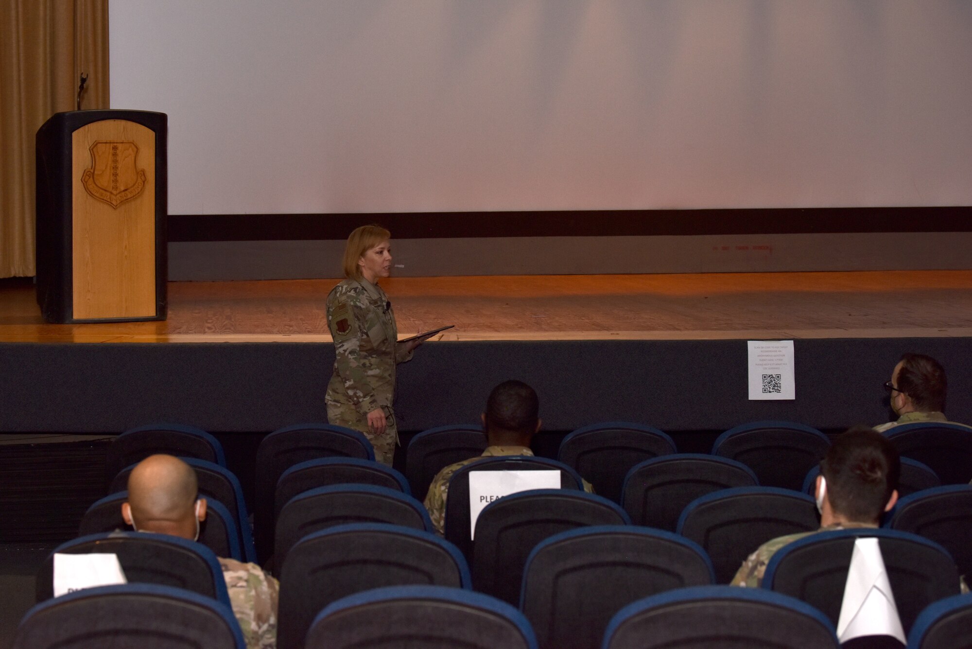 U.S. Air Force Chief Master Sgt. Casy Boomershine, 17th Training Wing command chief, holds an enlisted call in the base theater on Goodfellow Air Force Base, Texas, Nov. 23, 2020. Individuals wore masks and sat six feet apart to abide by Centers for Disease Control and Prevention guidelines. (U.S. Air Force photo by Staff Sgt. Seraiah Wolf)