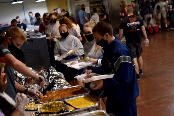 Goodfellow members walk down the serving line receiving food during the early Thanksgiving meal at The Crossroads Student Center on Goodfellow Air Force Base, Texas, Nov. 24, 2020. Students could social distance at some tables inside or take their food back to their dorms. (U.S. Air Force photo by Staff Sgt. Seraiah Wolf)