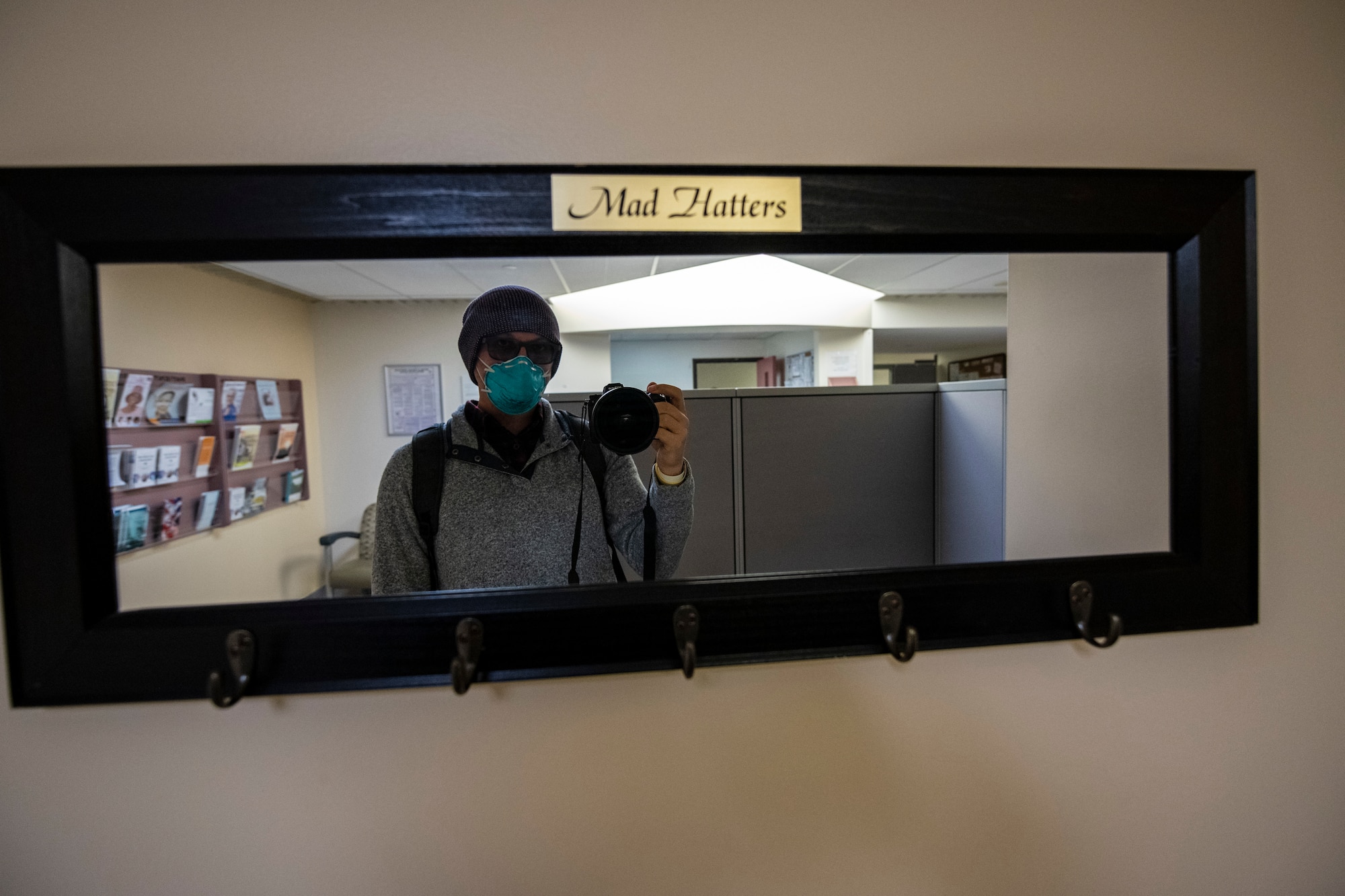 A man takes a picture of himself in a mirror in a medical center.
