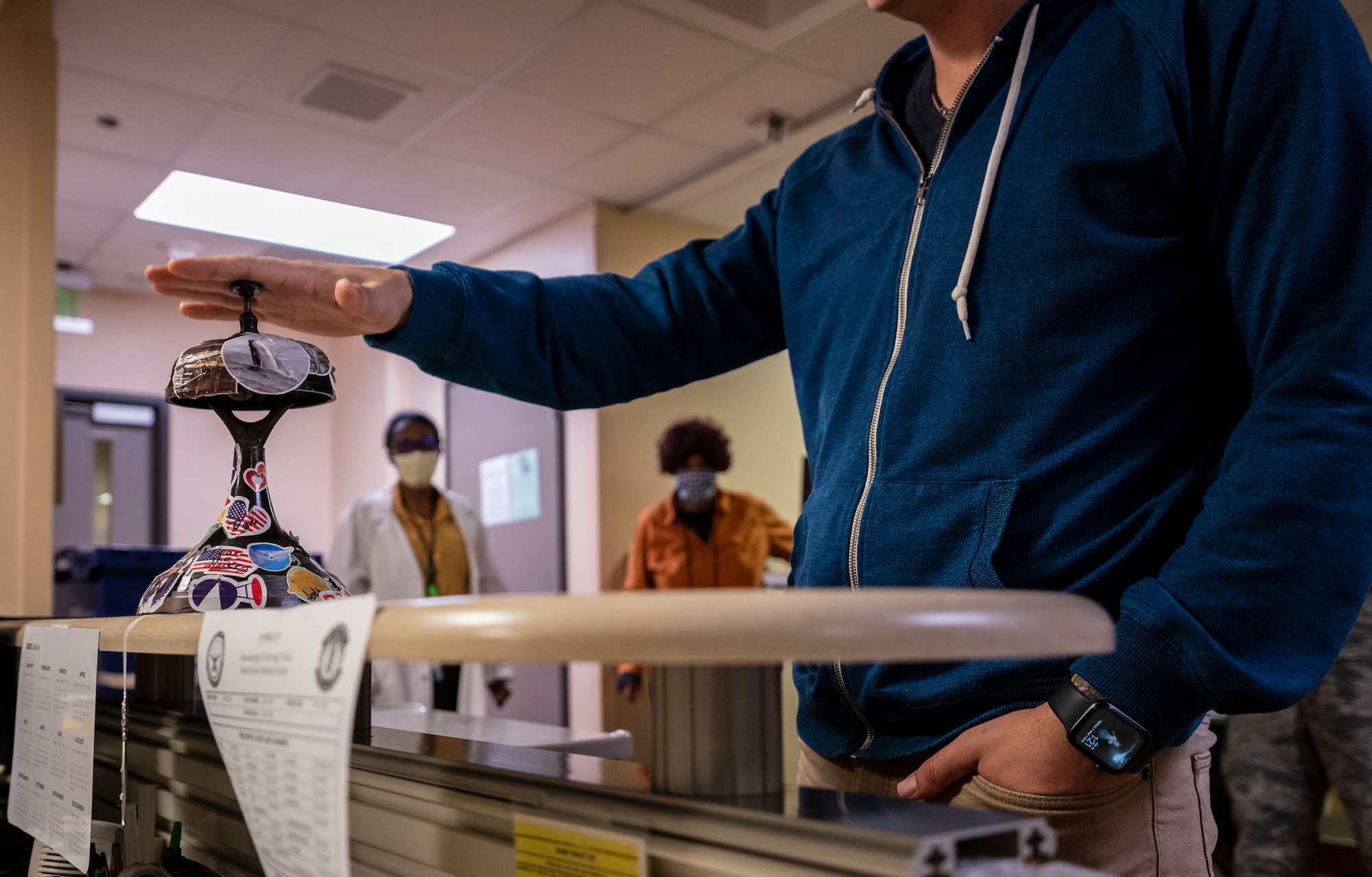 A man presses a button on a bell in a medical center.